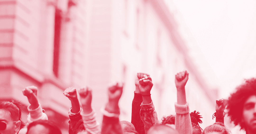 A red and white photo of a number of fists raised in the air.